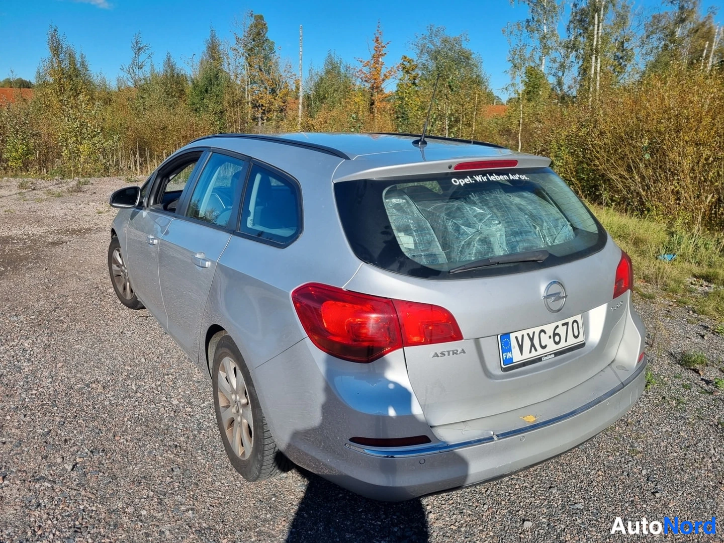 Takaviisto: Hopeanvärinen farmari takaa ja vasemmalta kyljeltä, ASTRA-merkintä takaosassa.