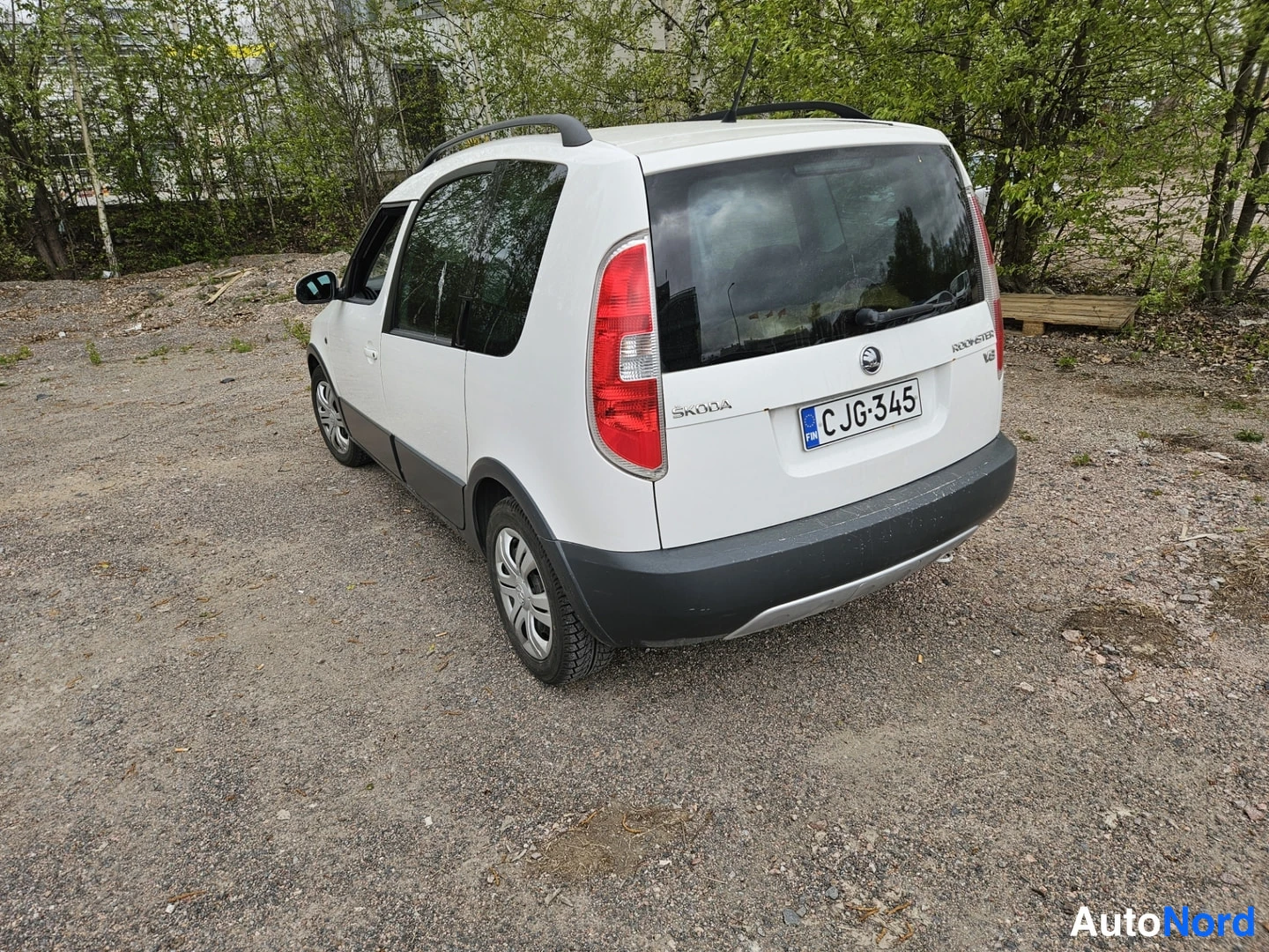Takaviisto: Valkoinen tilavautomobiili takaa kolmesta neljäsosakulmasta, perä ja oikea kylki näkyvissä, pystysuorat takavalot ja kattokaaret.