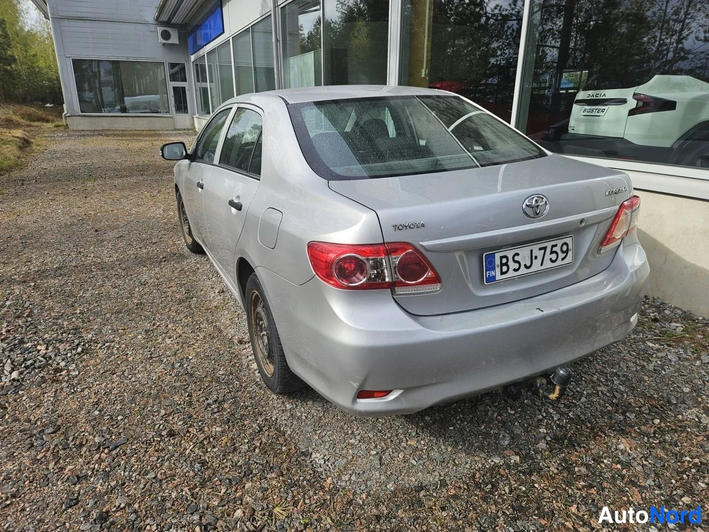 Takaviisto: Hopeanvärinen Toyota Corolla -henkilöauto kuvattu takaa vasemmalta, rekisteritunnus, takana vetoaisa.