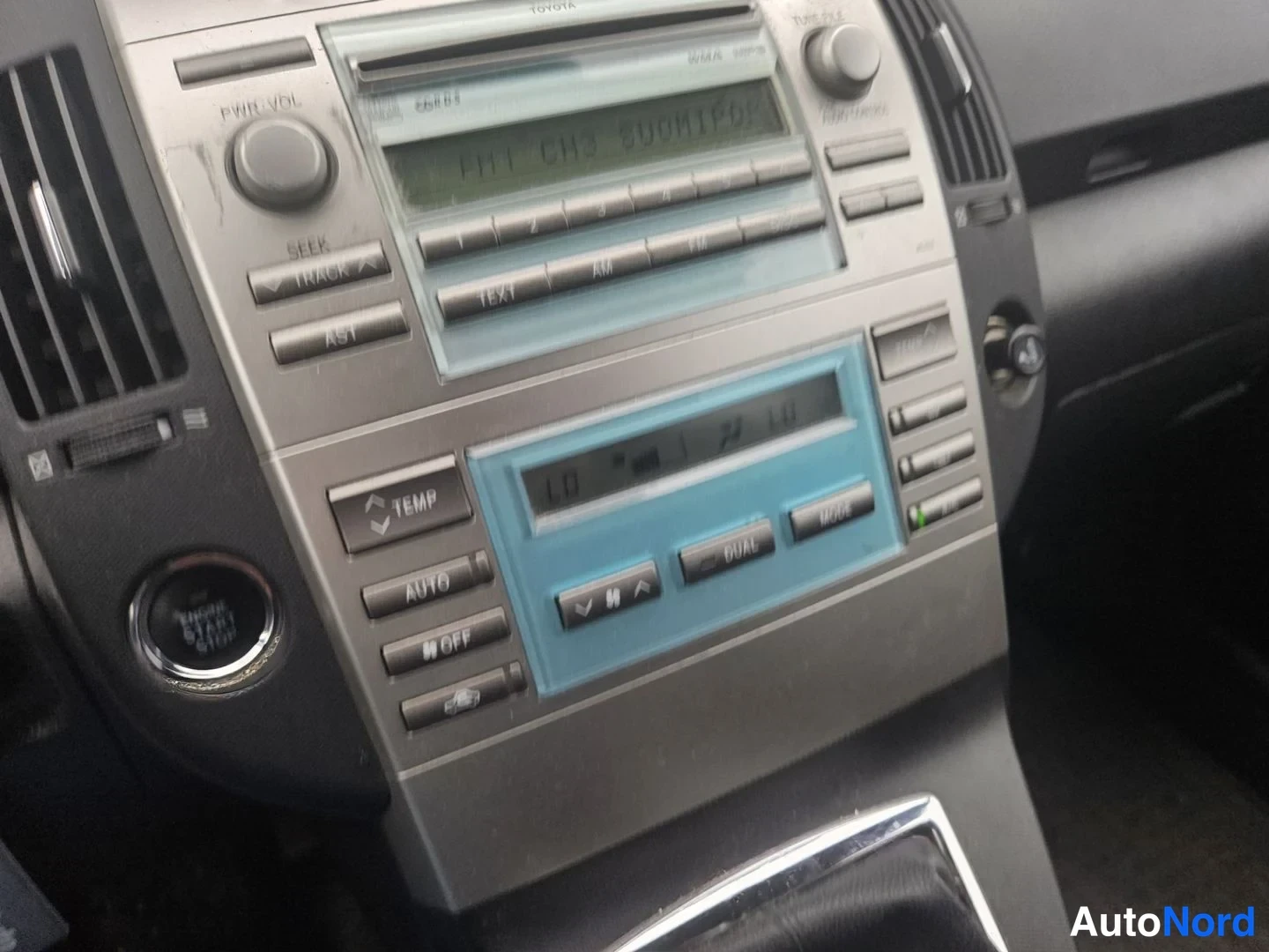 Muu: Kojelaudan keskusyksikkö: radio ja automaattinen ilmastointi, näppäimet AUTO, DUAL ja TEMP näkyvät.