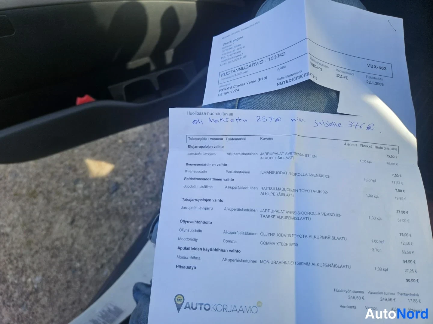 Asiakirja: Palvelulasku, jossa on käsin kirjoitettuja tietoja. Lähellä näkyy autojen istuinten pohjakohda.