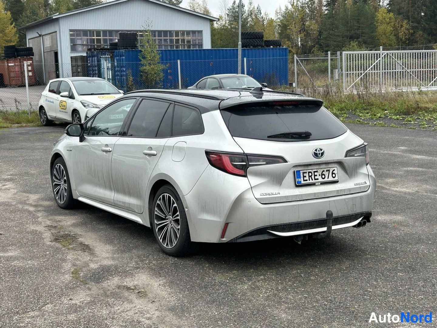 Takaviisto: Hopeanharmaa farmariauto kolmesta neljänneksestä takaa vasemmalta, rekisterikilpi.