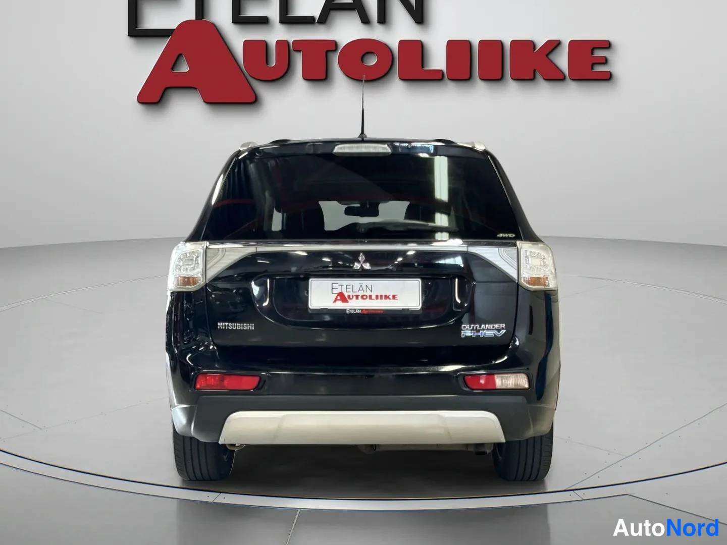 Takaa: Musta tila-auto suoraan takaa; takavalojen, takaluukun, Mitsubishi-tunnuksen ja takapuskurin näkyvät kuvassa.