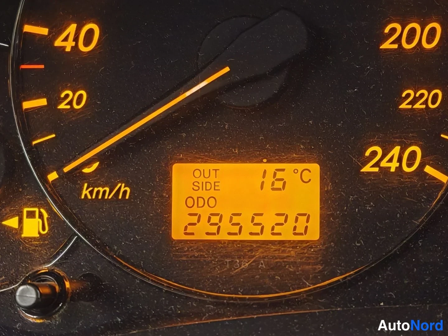 Edestä: Nopeusmittarin ja matkamittarin näyttö keltapohjaisella mittaristolla, lämpötila 16 °C ja ODO 295520 km.