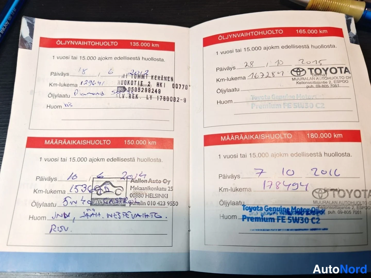 Muu: Huoltokirjan avattu sivu, jossa merkit öljynvaihto- ja määräaikaishuolloista 135 000–180 000 km lukemilla, Toyota-leimoilla.