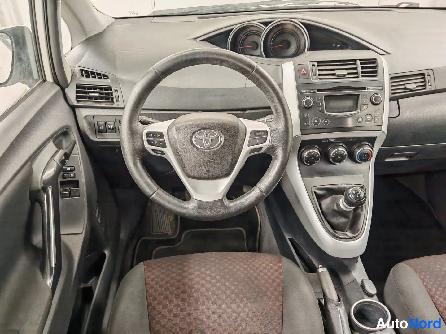 Muu: Ohjaamo suoraan edestä: Toyota-merkkinen ohjauspyörä, analogiset mittarit, keskikonsolin radio ja kolme lämmitystehonsäädintä, manuaalivaihteen vaihdevipu ja ka