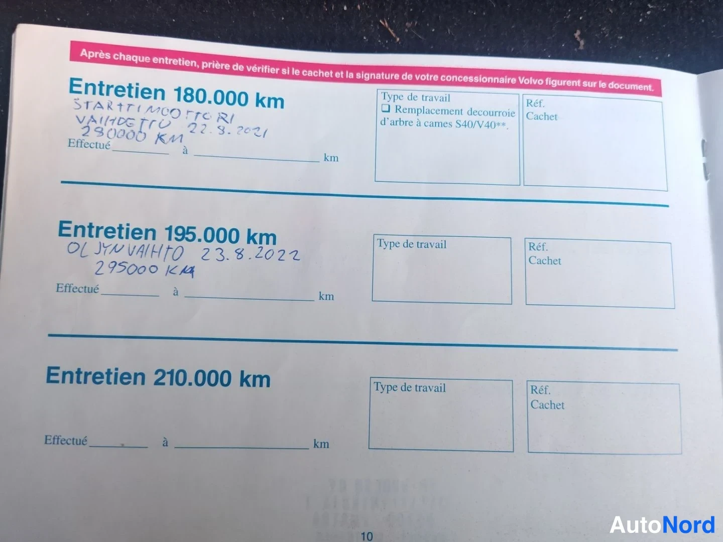 Muu: Volvo-huoltokirjan sivu, jossa käsinkirjoitetut merkinnät huolloista 180 000 km ja 195 000 km.
