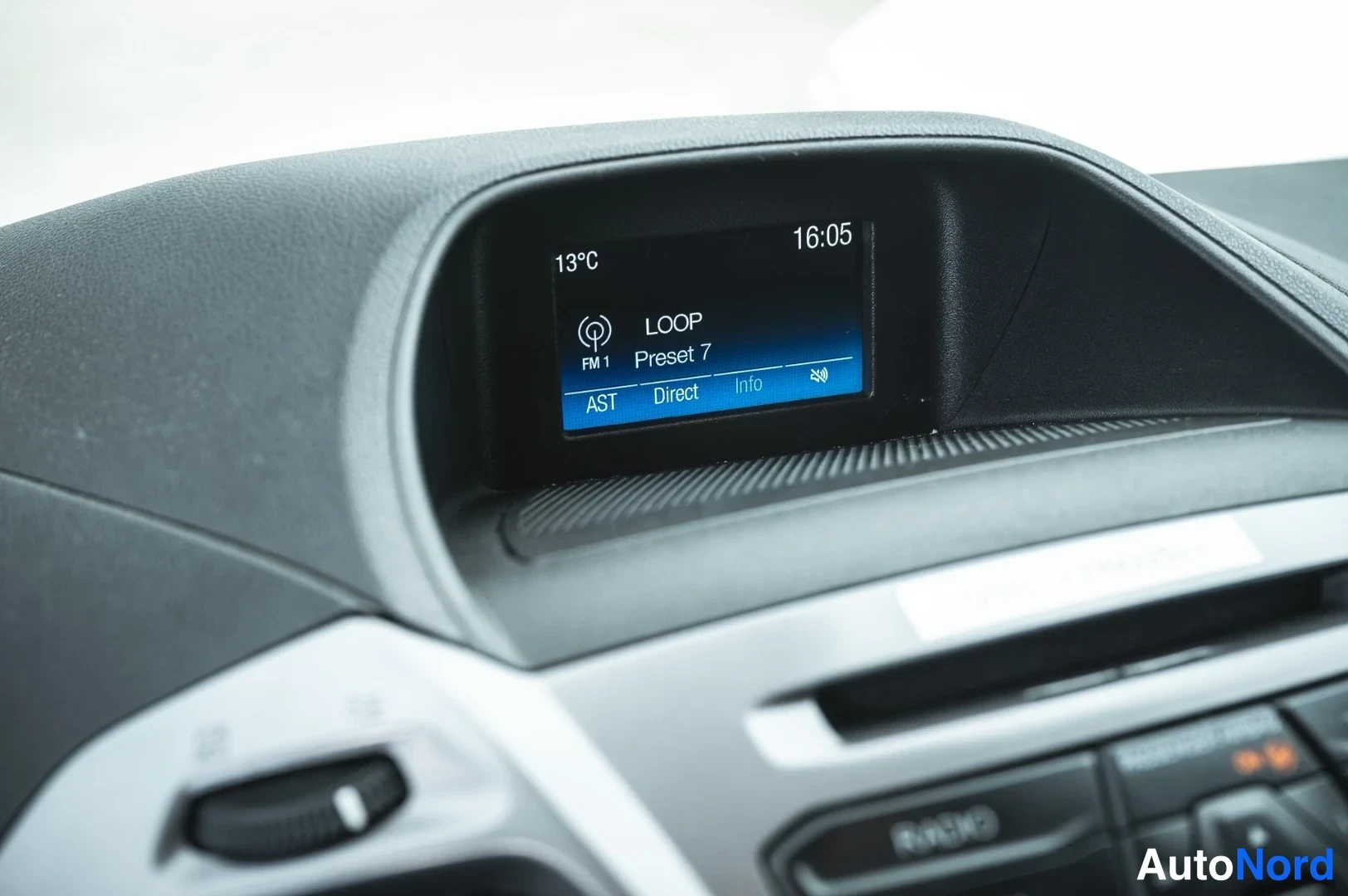 Muu: Kojelaudan infonäyttö näyttää radioaseman LOOP, esiasetuksen 7, lämpötilan 13 °C ja ajan 16.05; alla radio painikkeineen.