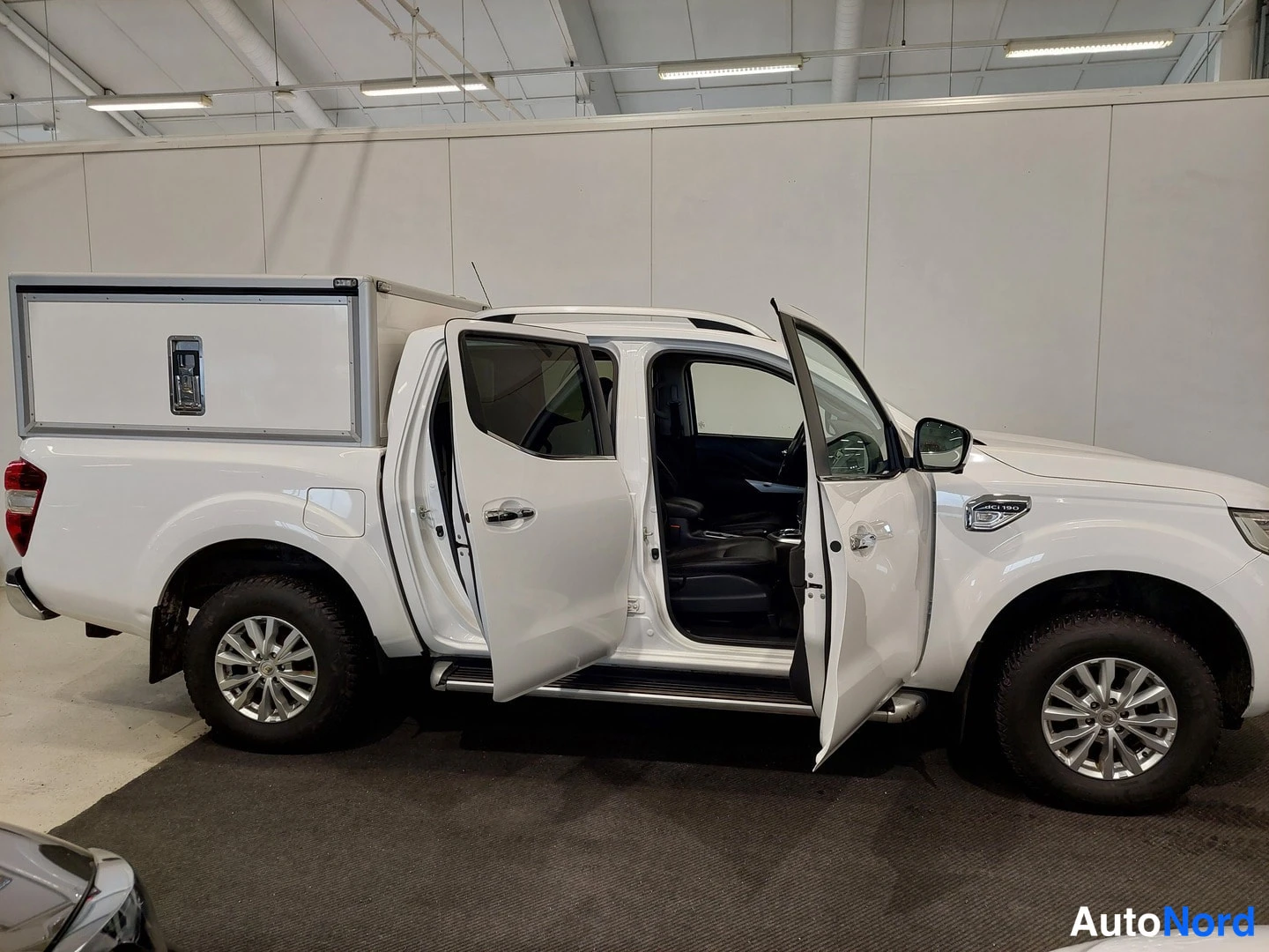 Sivulta: Renault Alaskan -nottomallin oikea kylki valokuvattuna sisätiloissa. Ovet ovat auki ja palvelulaatikko näkyy lavalla.