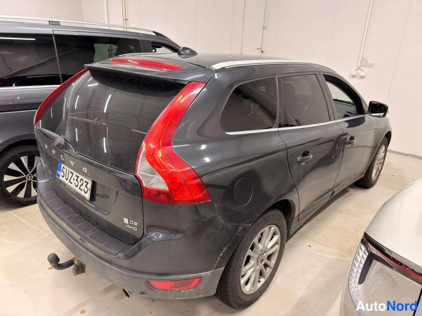 Takaviisto: Tummanharmaa Volvo XC60 takaa kolmesta neljänneksestä, rekisterikilpi, vetokoukku näkyvissä.