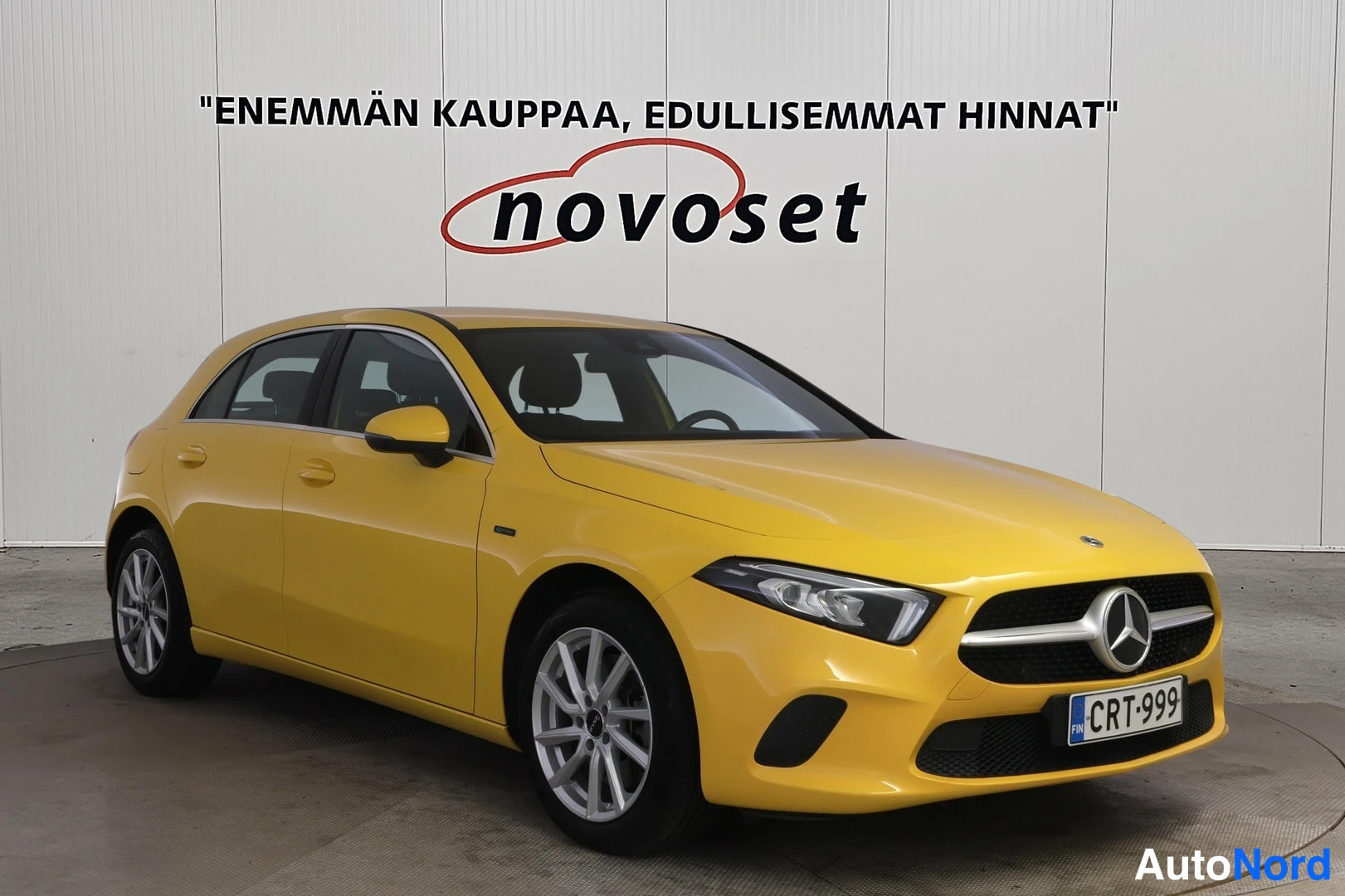 Etuviisto, nokka oikealle: Keltainen Mercedes-Benz A -malli kuvattu etuviistosta oikeaan osoittavalla keulalla, rekisteritunnus.