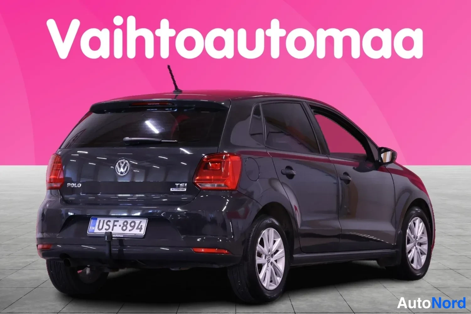 Takaviisto: Tummanharmaa Volkswagen Polo takaa oikealta kallistettuna, POLO- ja TSI-tekstit takaluukussa, rekisteritunnus.