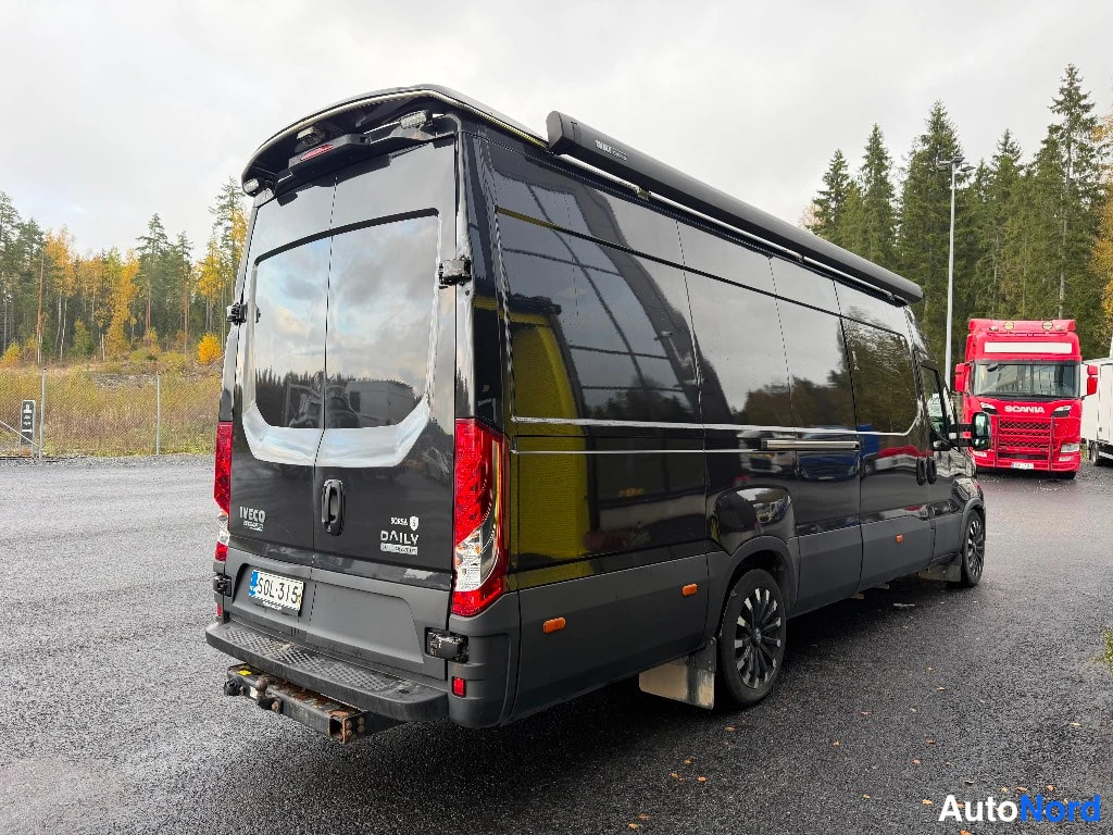 Takaviisto: Musta Iveco Daily -pakettiauto takakulmasta kuvattuna, taaosa ja vasen kylki näkyvissä, katossa pitkä kasetti.