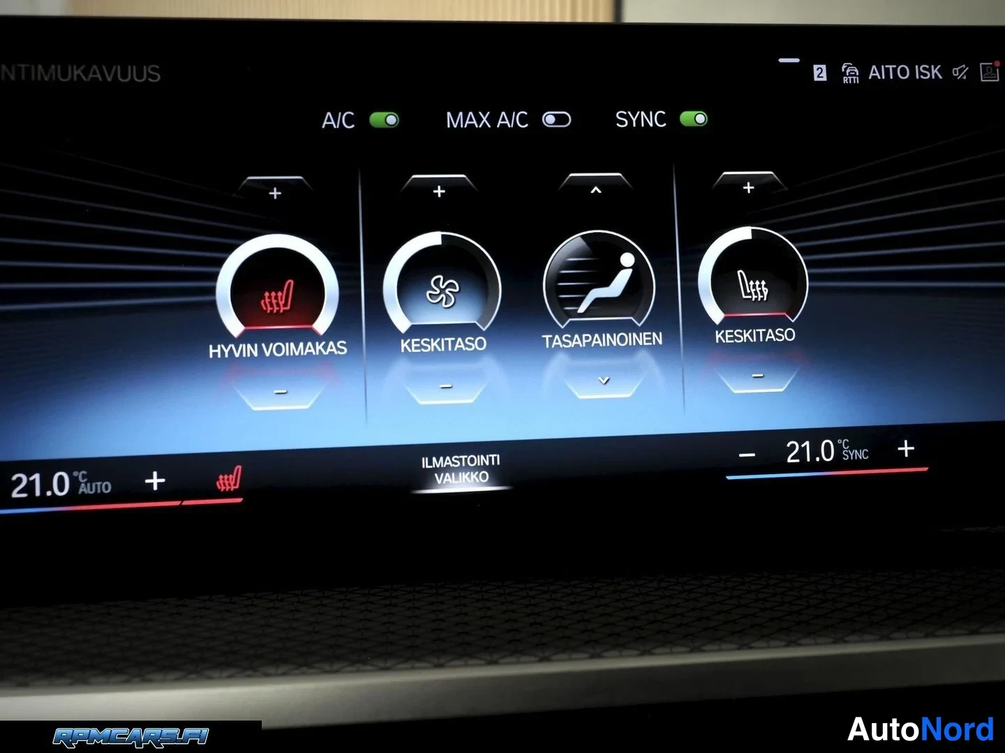 Yksityiskohta: Auton infotainment-näytön ilmastointiasetukset: A/C ja SYNC päällä, lämpötila 21,0 °C molemmin puolin, puhallustaso keskitaso ja lattia-(HYVIN VOIMAKAS)-asetus