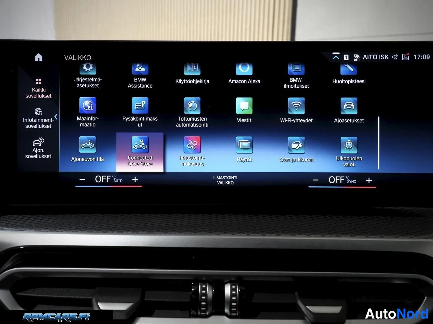 Muu: Auton infotainment-näytön VALIKKO-näkymä sovelluskuvakkeineen, kuten BMW Assistance, Amazon Alexa ja Connected Drive Store.