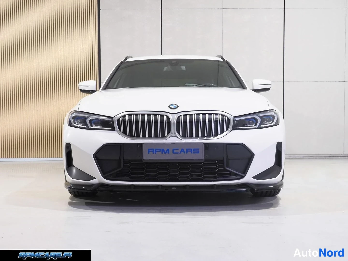 Edestä: Valkoisen BMW-auton etusivusta suora etunäkymä: munuaissäleikko, LED-ajovalot ja etupuskurin ilmanottoaukot näkyvät.