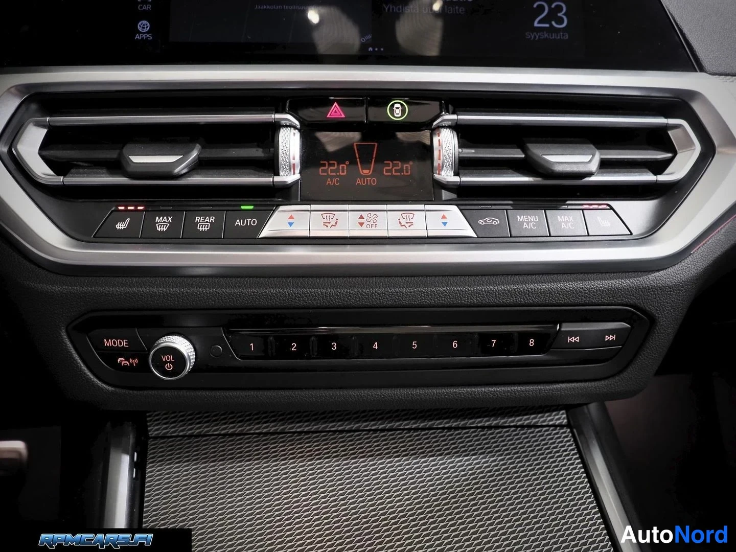 Edestä: Lähikuva ilmastointipaneelistta: kaksi 22,0° lukemaa, napit MAX, REAR, AUTO, MAX A/C, MENU A/C, ohjauspyörän lämmitys, istutinlämmitys sekä MODE ja VOL -säädöt.