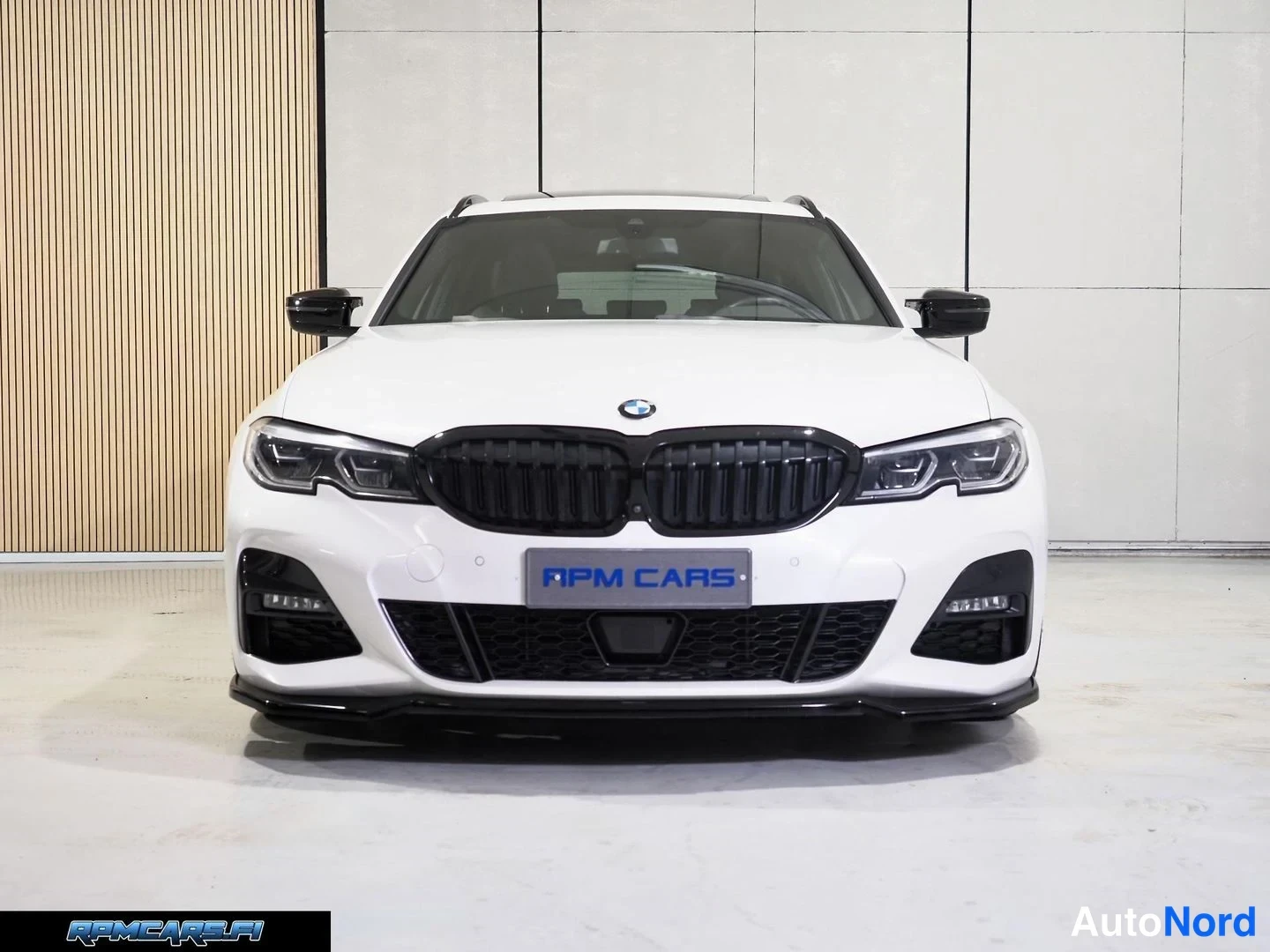 Edestä: BMW Farmingin etunäkymä valkoisella korilla, tummat etuvalot ja etupuskuri kuvassa.