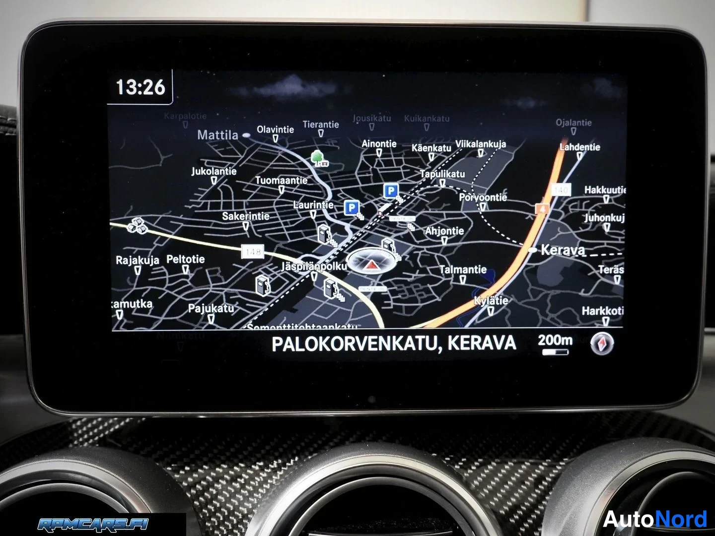 Muu: Lähikuva kojelaudan infotainment-näytöstä, jossa näkyy karttanavigointi tekstillä PALOKORVENKATU, KERAVA, kello 13:26 ja etäisyys 200m.