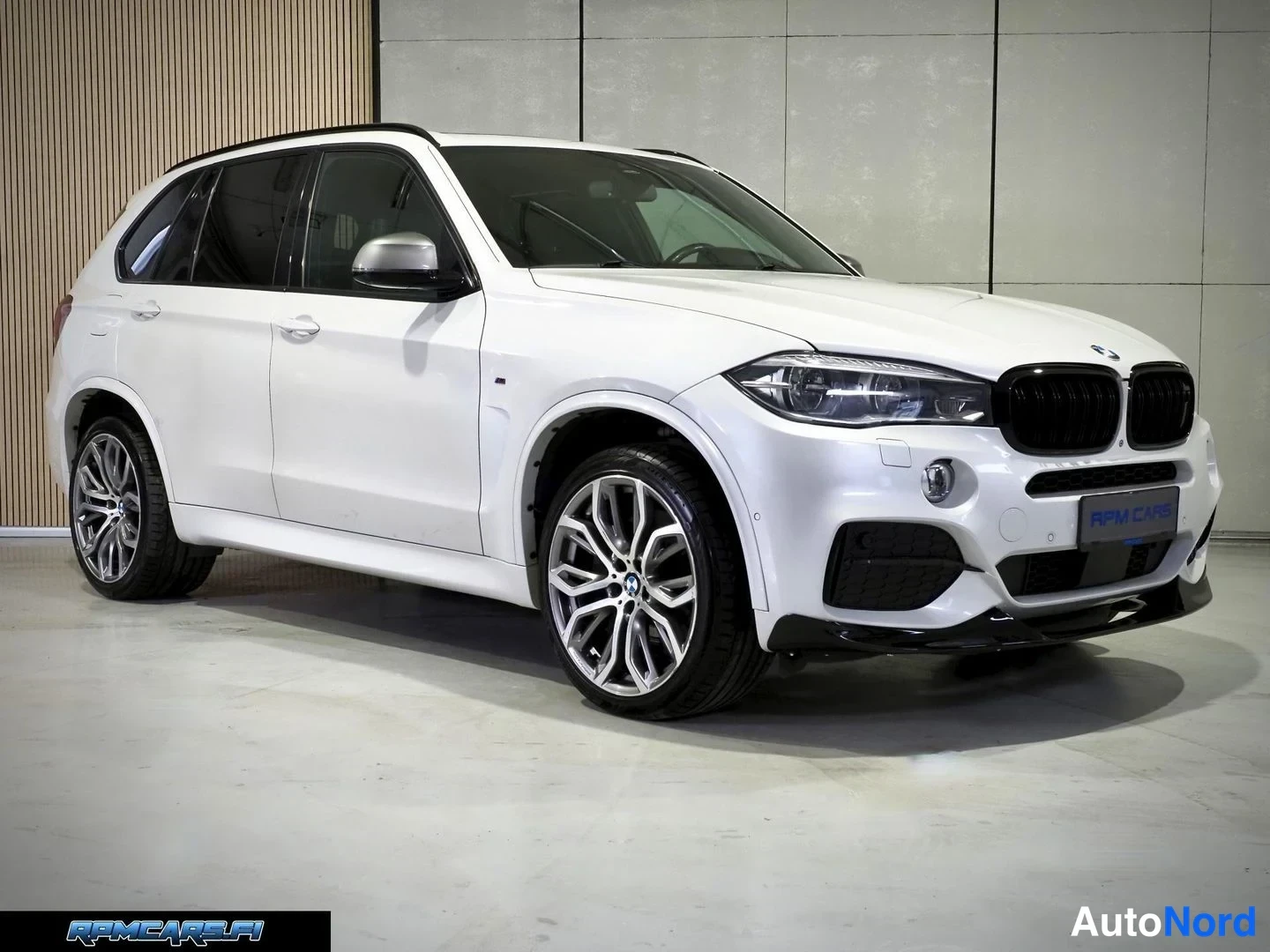 Etuviisto, nokka oikealle: Valkoisen BMW:n etukulmanäkymä oikealta: musta etusäleikkö, LED-etuvalot, sumuvalot ja monisakeiset kevytmetallivanteet.
