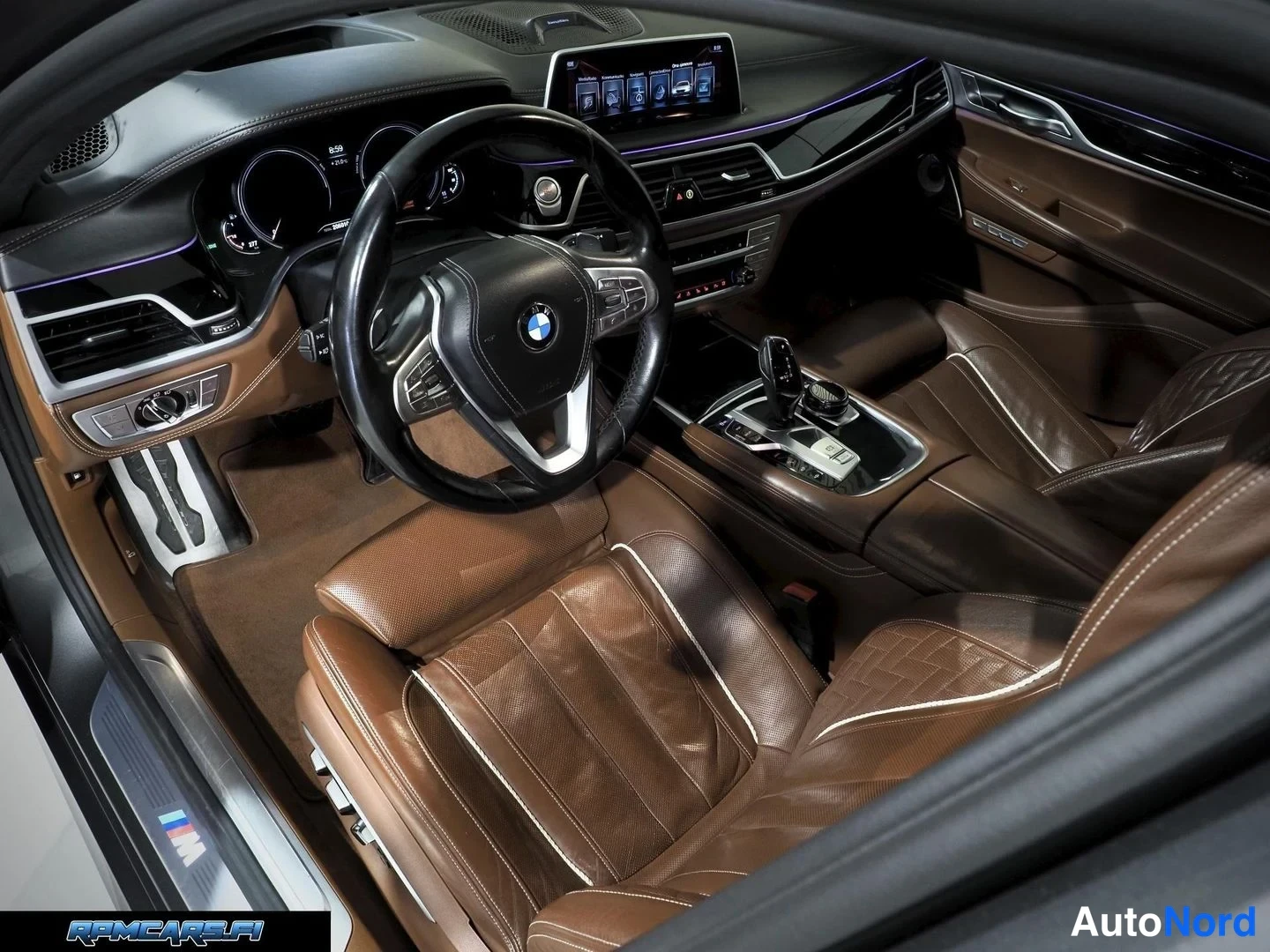 Muu: Kuljettajan puoleinen yleiskuva BMW:n ohjaamosta: ruskeat nahkaistuimet, monitoimorengas, infotainment-näyttö ja automaattivaihteiston valitsin.
