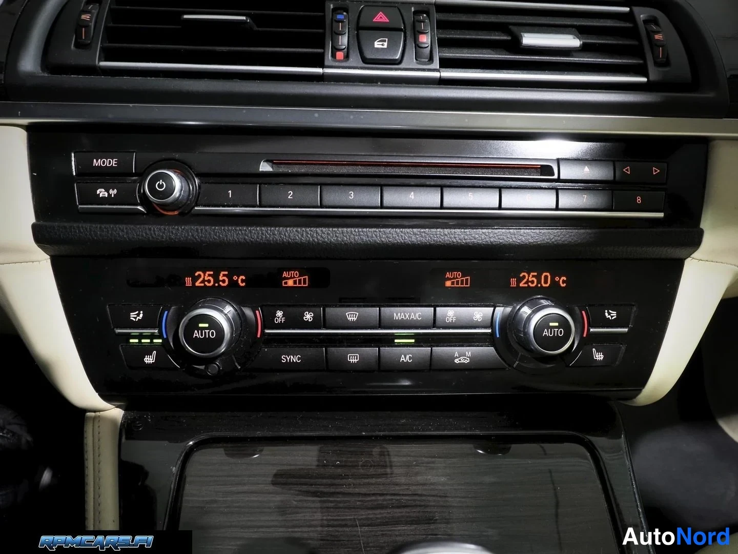 Muu: Lähikuva BMW:n keskusyksiköstä ja kaksialueisesta automaattilmastoinnista: näytöllä lämpötilat 25,5 °C ja 25,0 °C, MODE-, SYNC-, MAX A/C- ja A/C-painikkeet.