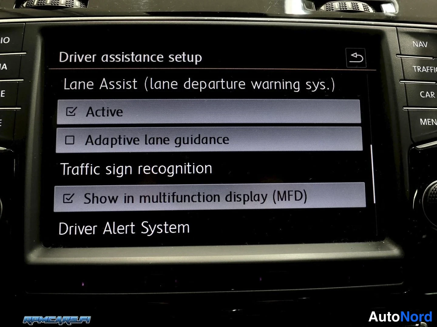 Yksityiskohta: Auton kojelaudan näytöltä kuvattu Driver assistance setup -valikko, jossa Lane Assist on aktiivisena ja Traffic sign recognition asetettu näkymään monitoiminäyt