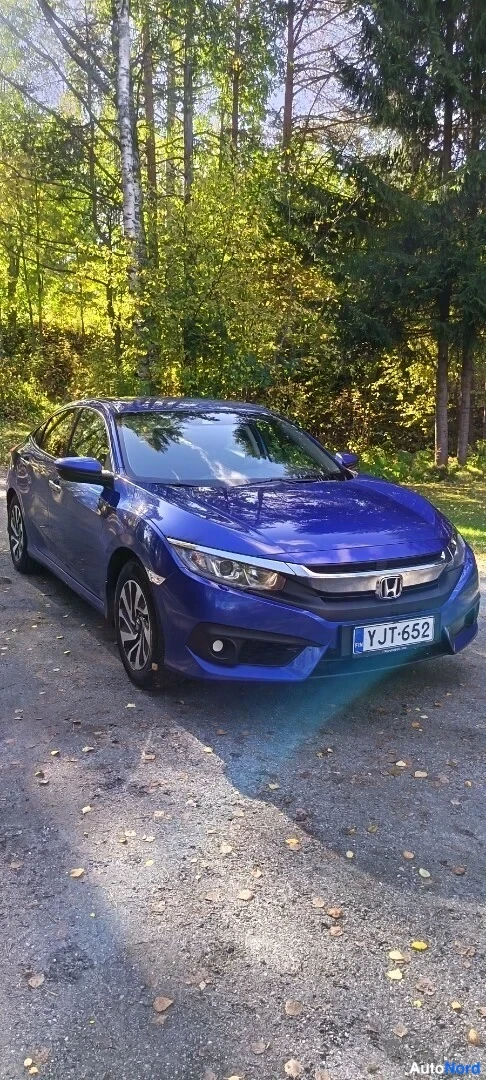 Etuviisto, nokka oikealle: Sininen Honda Civic -sedan etukulmasta oikealta, rekisteritunnus hiekkatiellä.