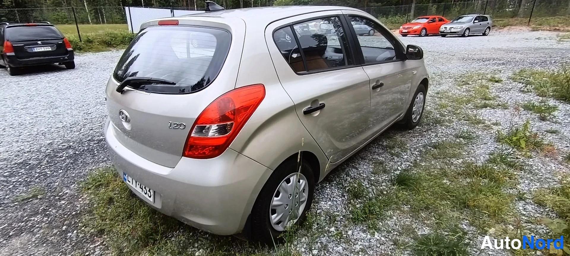 Takaviisto: Hyundai i20 t takakulmasta, vaaleanbeige kori, i20-merkintä takaluukussa, rekisteritunnus.