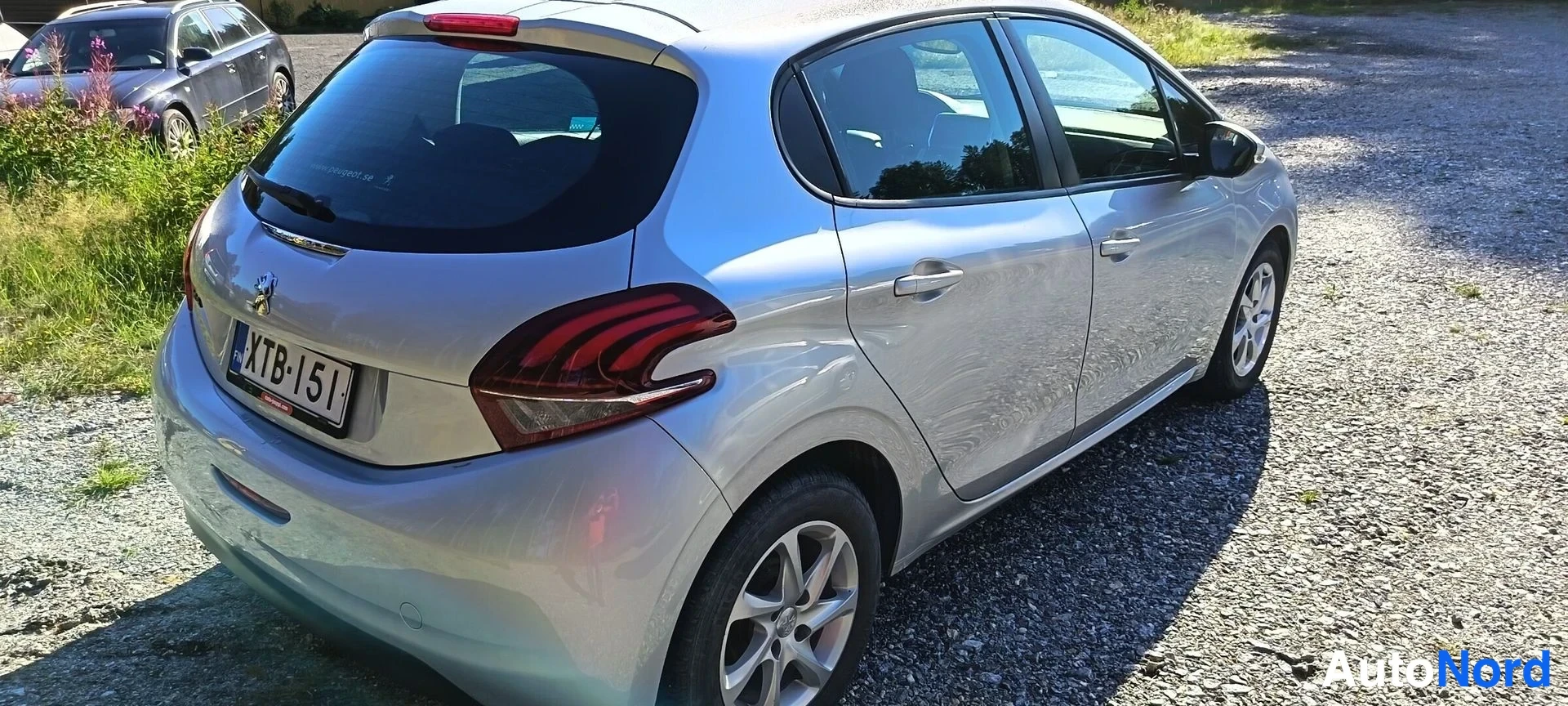 Takaviisto: Hopeanvärinen Peugeot 208 viistoperä takaa ja oikealta sivulta, rekisteritunnus.