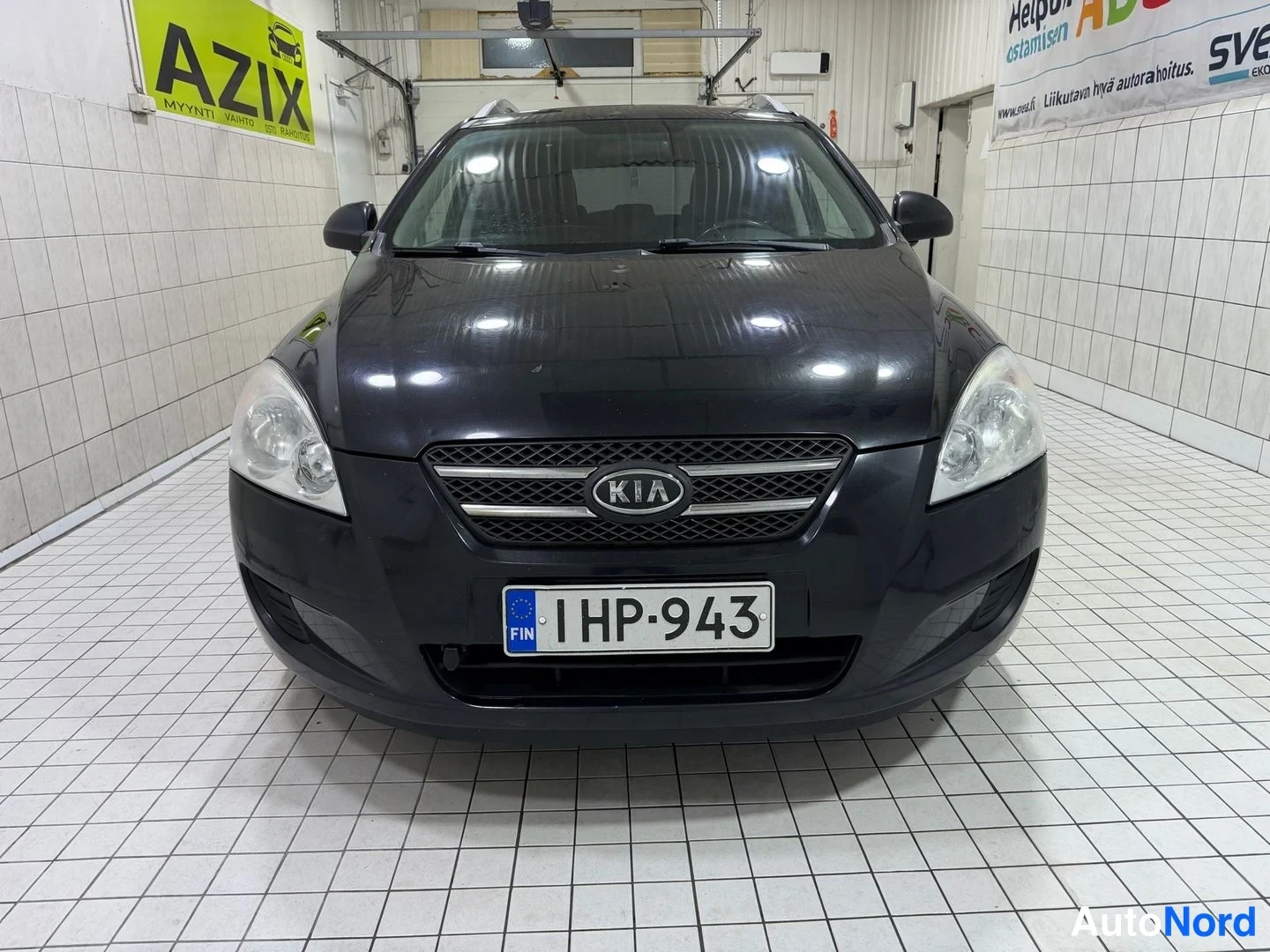 Edestä: Kia Ceed suoraan edestäpäin, tumma koriväri, KIA-merkki etusäleikössä ja rekisterikilpi etupuskurissa.