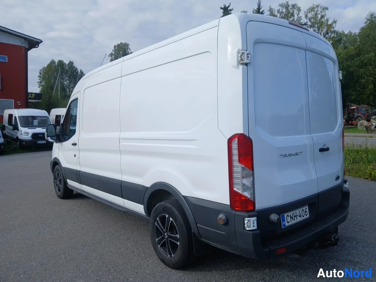 Takaviisto: Pakettiautin takakulmanäkymä: valkoinen Ford Transit, takavalo ja rekisterikilpi näkyvät.