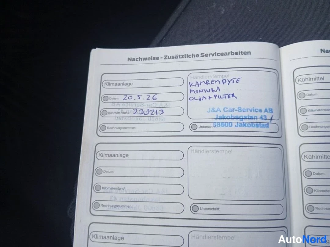 Yksityiskohta: Huoltokirjan sivu otsikolla 'Nachweise - Zusätzliche Servicearbeiten', käsin kirjoitetut merkinnät ilmastointilaitteen huollosta 20.5.2026 klo 230213 km sekä va