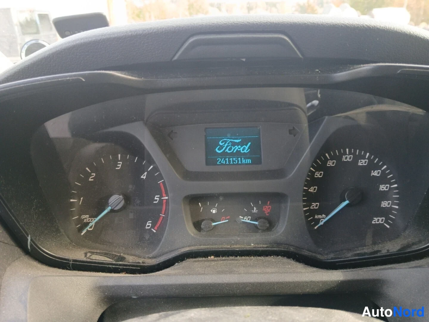 Muu: Ford-merkkisen ajoneuvon mittaristo: nopeusmittari 200 km/h asti, kierrosmittari ja näytössä lukema 241151 km.