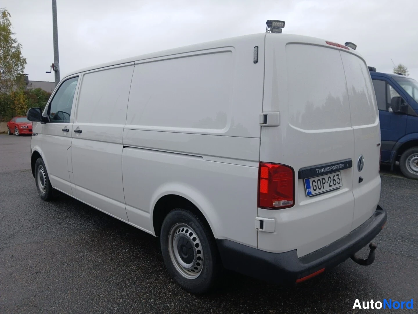 Takaviisto: Valkoisen pakettiauton takaosa ja vasen kylki, rekisterikilpi ja kirjoitus Transporter takaluukussa.
