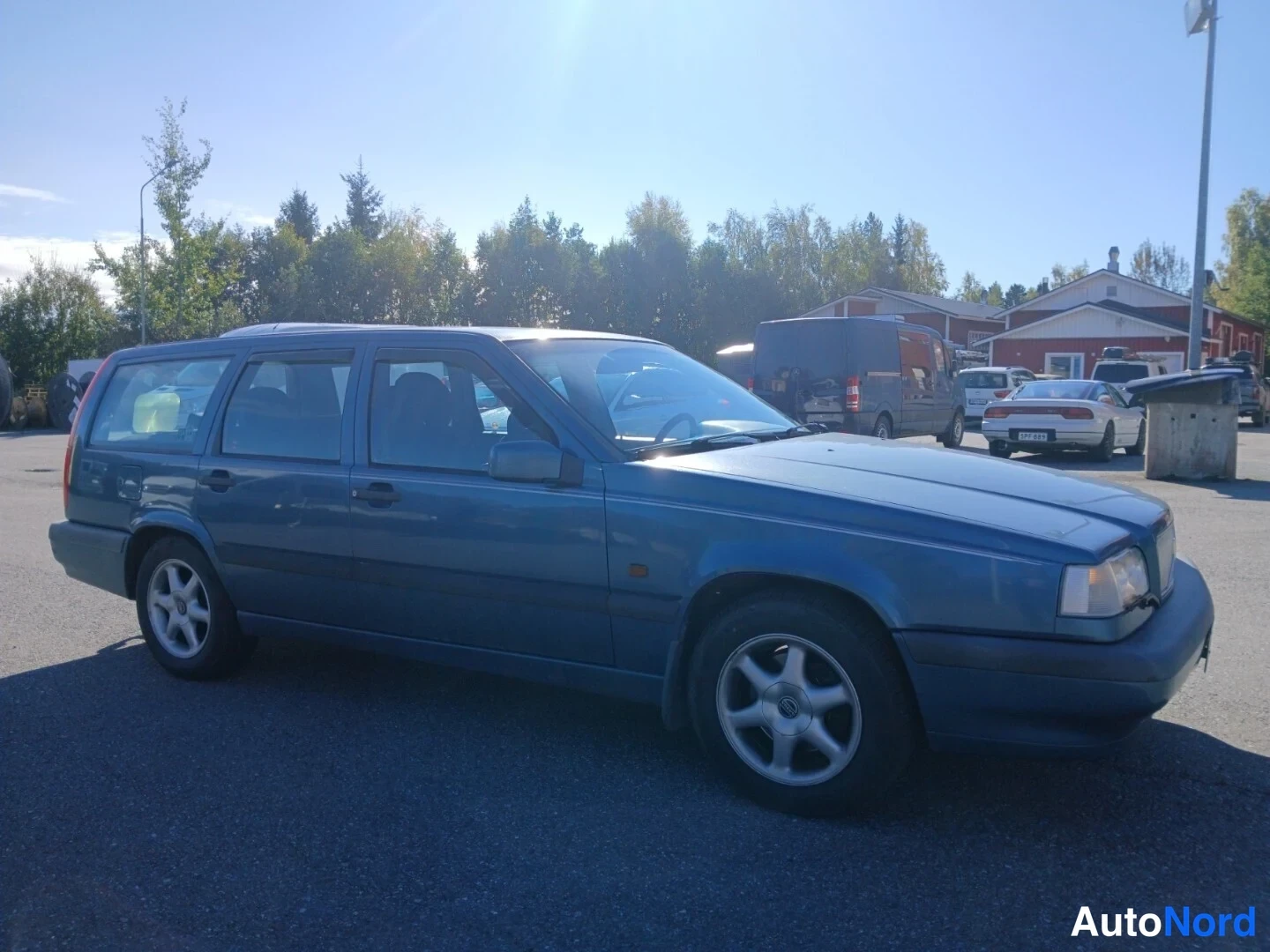 Etuviisto, nokka oikealle: Sininen farmarinauto etuosa-nurkkakuvassa, keula oikealla.