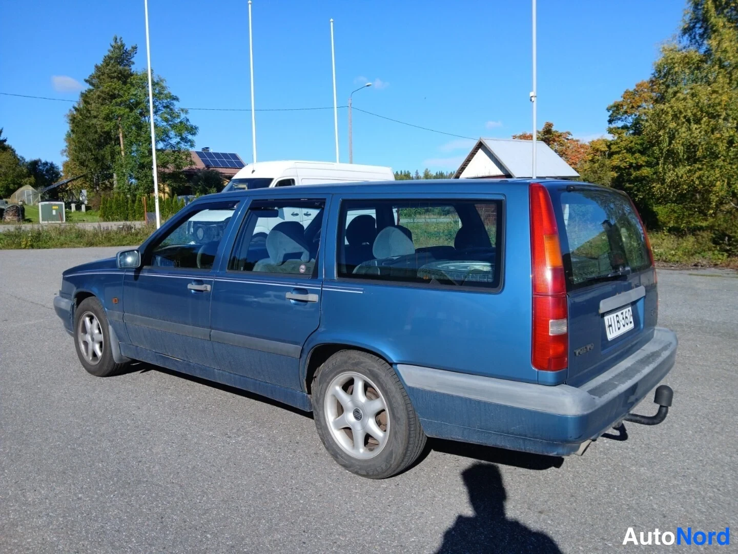 Takaviisto: Sininen farmarinauto takaosa-nurkkakuvassa, rekisterikilpi näkyvissä.