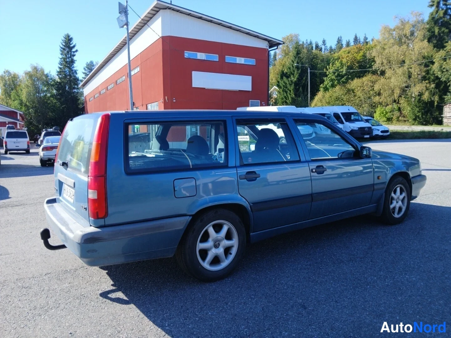Takaviisto: Sininen farmarinauto takaosa-nurkkakuvassa takaa vasemmalta kuvattuna.