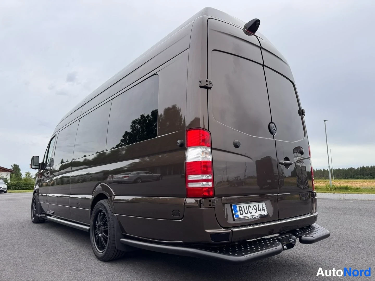 Takaviisto: Mercedes-Benz Sprinter -pakettiauton takaosasta viistosti otettu kuva, tummanruskea koripinta, mustat kevytmetallivanteet, rekisterikilpi.