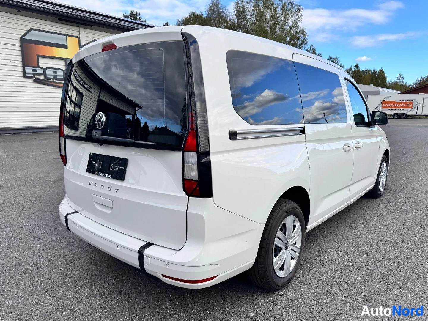 Takaviisto: Valkoisen Volkswagen Caddy -pakettiauton takaosa ja vasen kylki takakulmasta kuvattuna, takaluukussa CADDY-teksti.