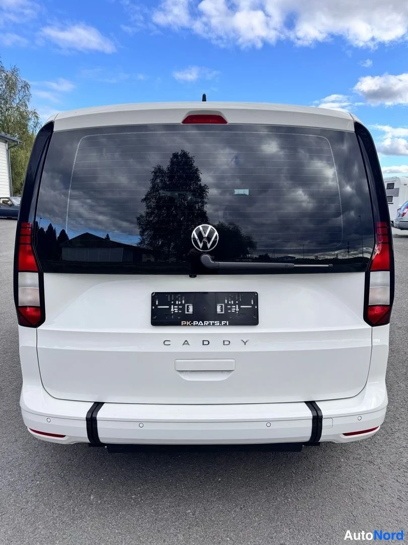 Takaa: Volkswagen Caddy takaa suoraan kuvattuna, valkoinen kori, CADDY-teksti takaluukussa ja rekisterikilven paikalla musta kilpi.