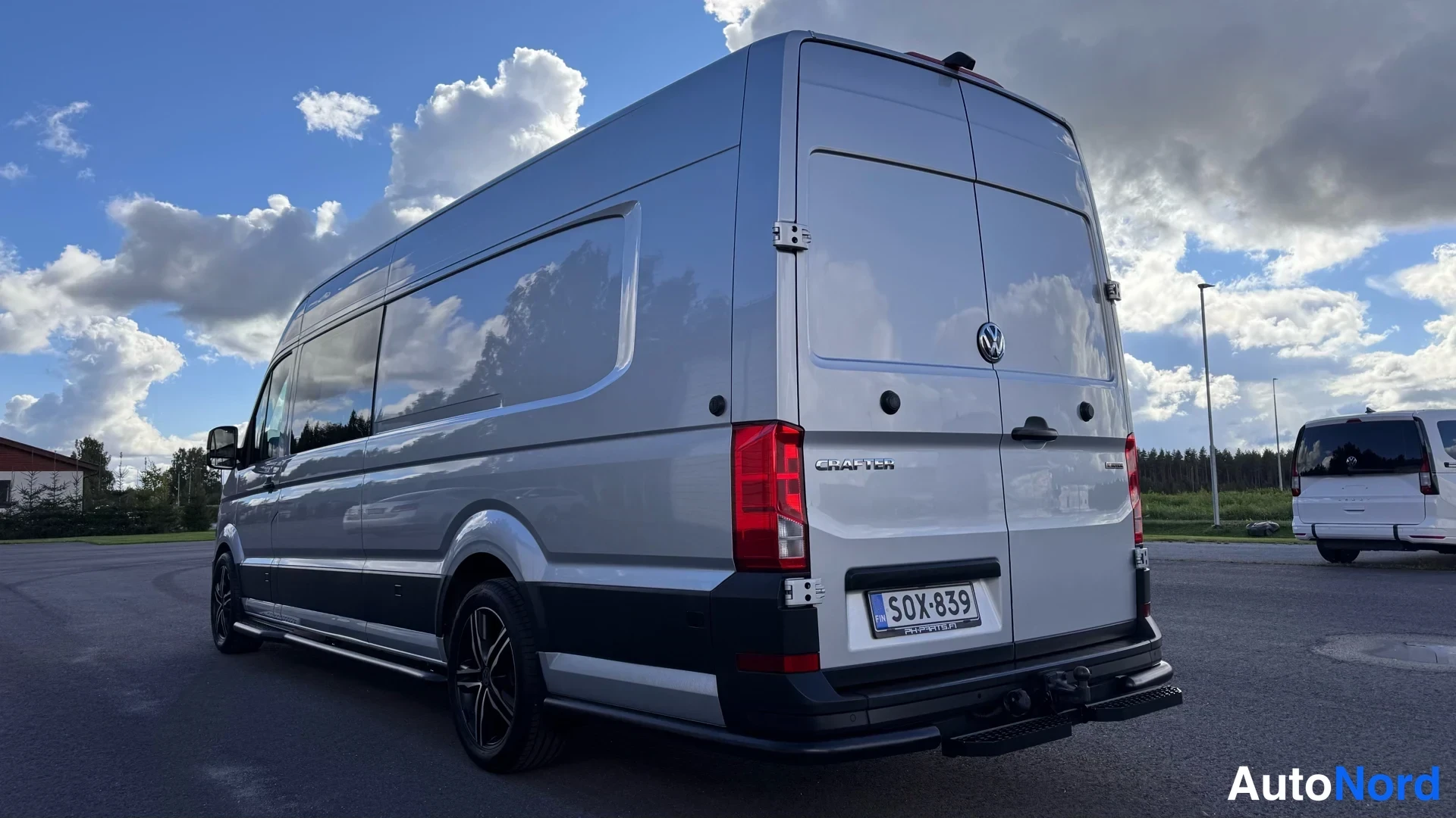 Takaviisto: Volkswagen Crafter -pakettiauto takaa sivulta kuvattuna, hopeinen koritakki ja mustat pyörät.