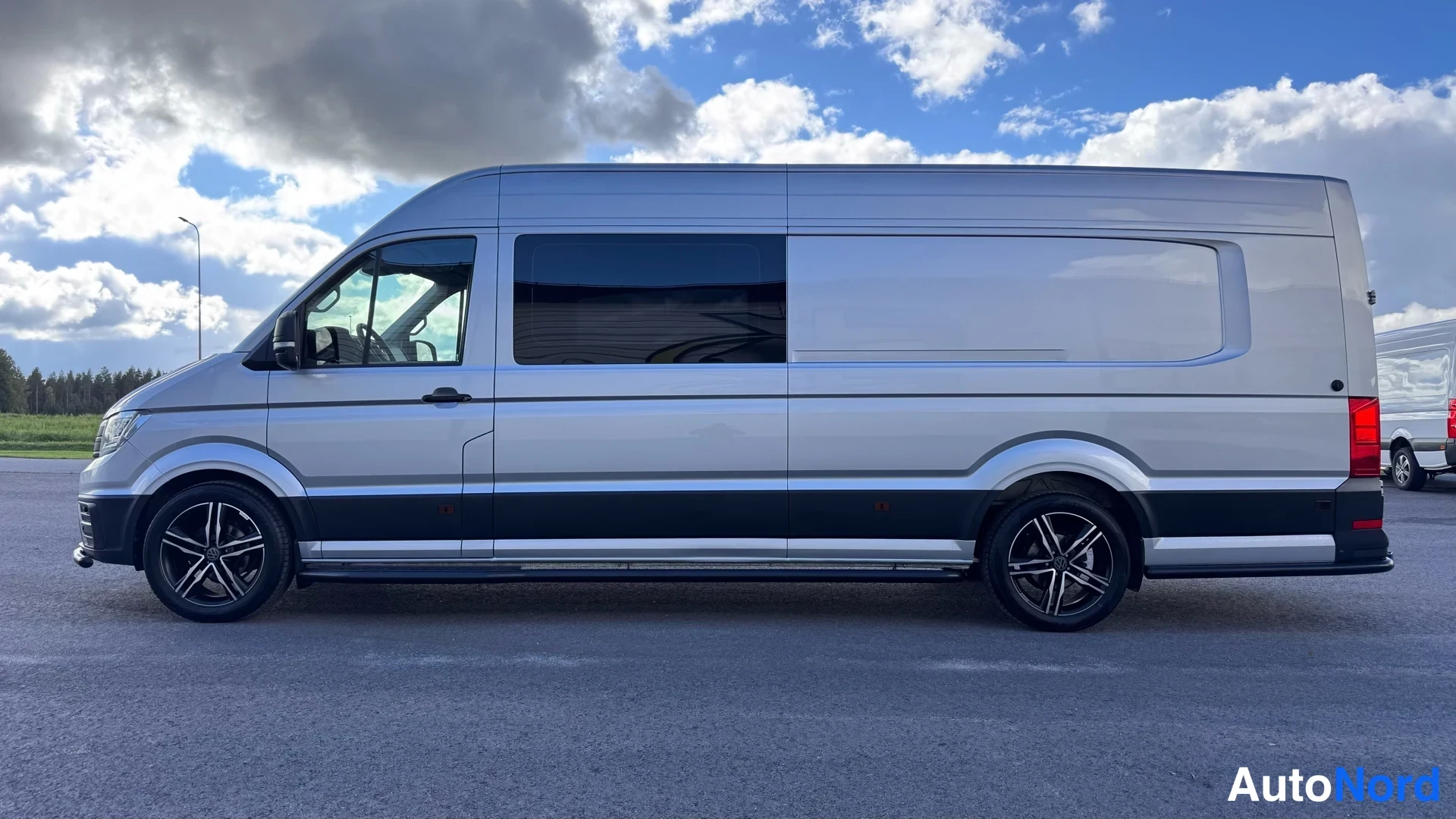 Sivulta: Volkswagen Crafter -pakettiauto sivulta kuvattuna, pitkälti toinen sivu ja mustat vanteet näkyvissä.