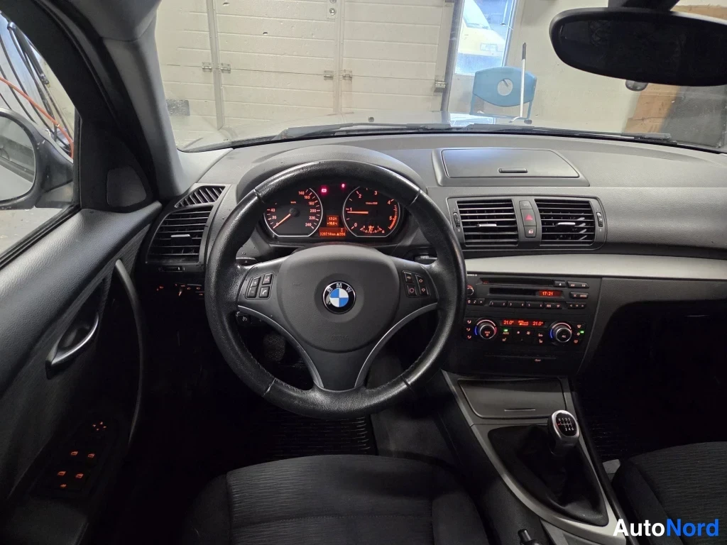 Sivulta: Kojetaulun näkymä kuljettajan paikalta, BMW-ohjauspyörä, mittaristo sekä manuaali vaihteenvaihtaja.