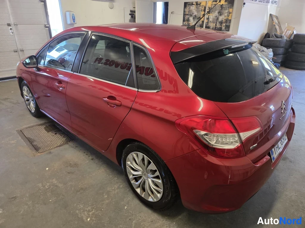 Takaviisto: Punainen Citroen C4 -henkilöauto sisätiloissa, takakulmanäkyvyys, tummat lasit