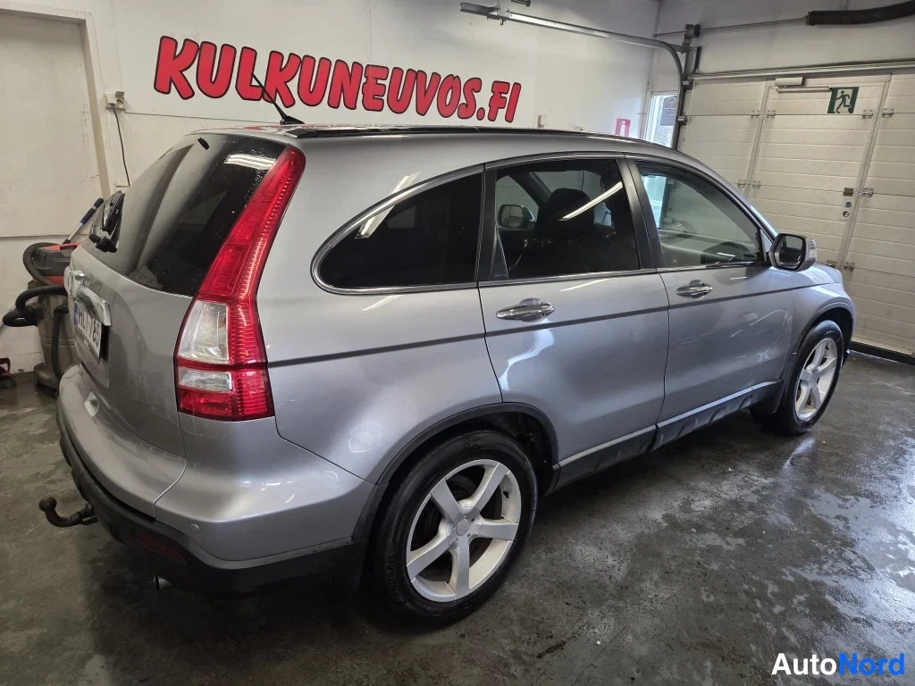 Takaviisto: Hopeanharmaa Honda CR-V takaosa vasemmasta kulmasta, auton takapää kuvan vasemmassa reunassa.