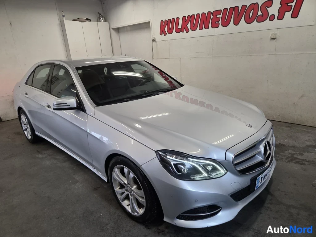 Etuviisto, nokka oikealle: Mercedes-Benz E-sarjan sedan etuviistosta oikealta, hopeisena sisätiloissa.