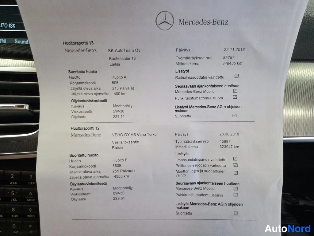 Asiakirja: Mercedes-Benzin huoltoraportti 13 ja 12 paperilla autonsisäpuolella, huoltojen päiväykset 22.11.2018 ja 28.06.2018.