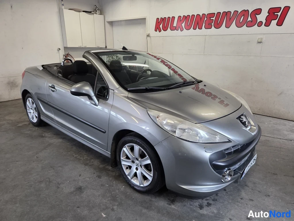 Etuviisto, nokka oikealle: Peugeot 207 -avolava huoltamoalueen lattialla, etupää oikealle kääntyneenä ja katto auki