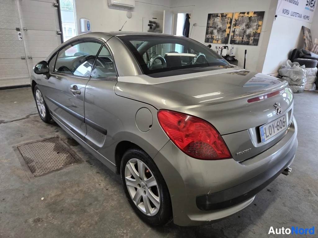 Takaviisto: Peugeot 207CC avomallin takapuoli ja kylki kuvan oikealla, harmaa runko, rekisteritunnus L0Y-606.